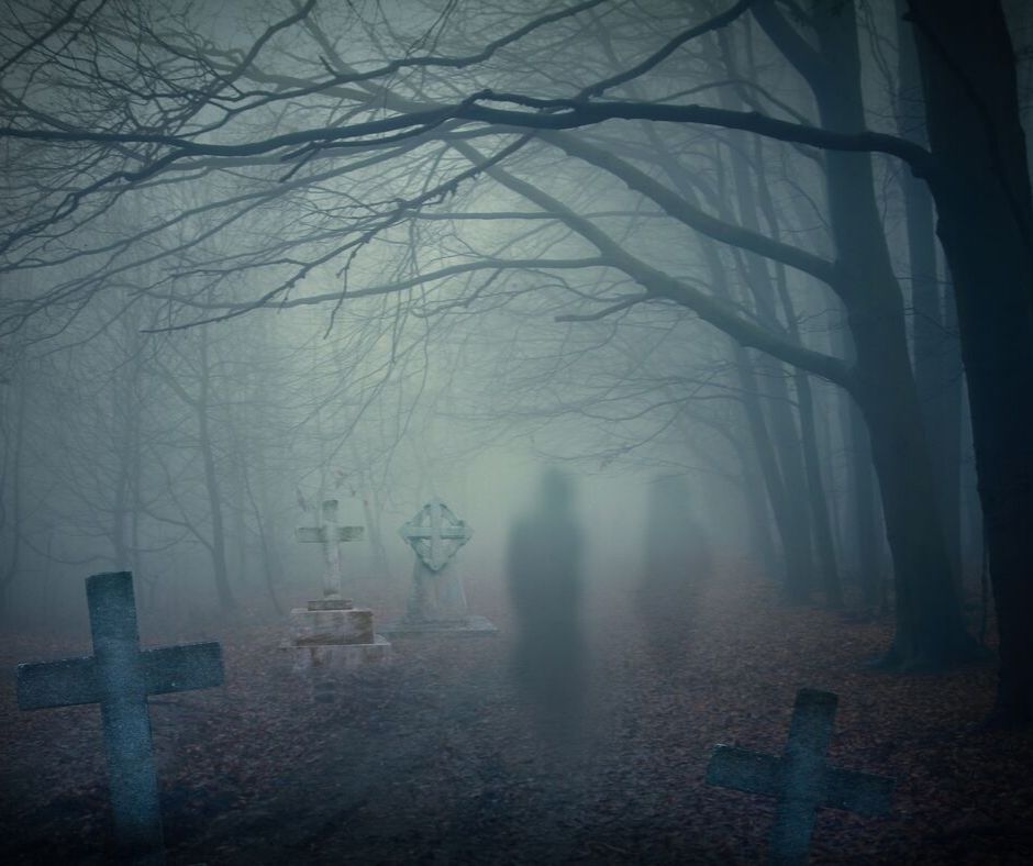 cemetery shrouded in fog with shadowy figures standing around