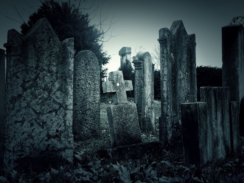 balck and white image of old headstones in a cemetery.