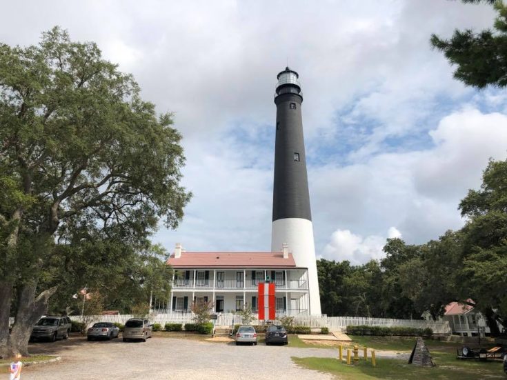 Pensacola light house with fluffy clouds in the sky.